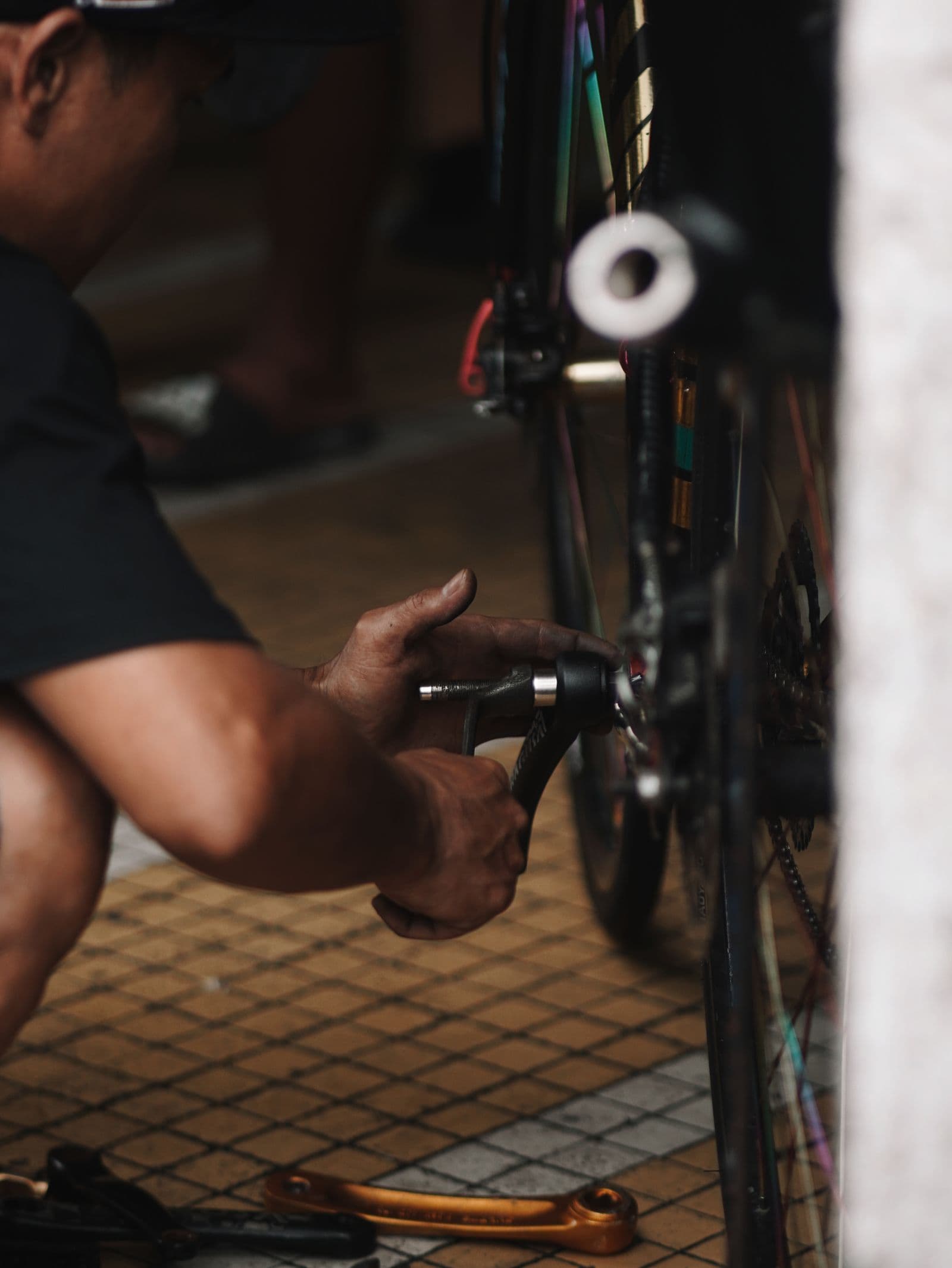 Grease-stained hands servicing a rear hub in a dark workshop